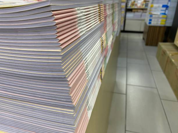 istock Book stack on wood desk and blurred bookshelf in the book store, education background, back to school concept 1488255624