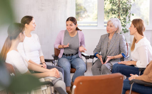 istock Women lead discussion sitting on chairs in circle 1488256816