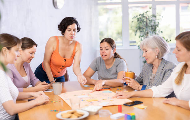 istock Young female moderator throws stones and determines order of parties in board game 1488256879
