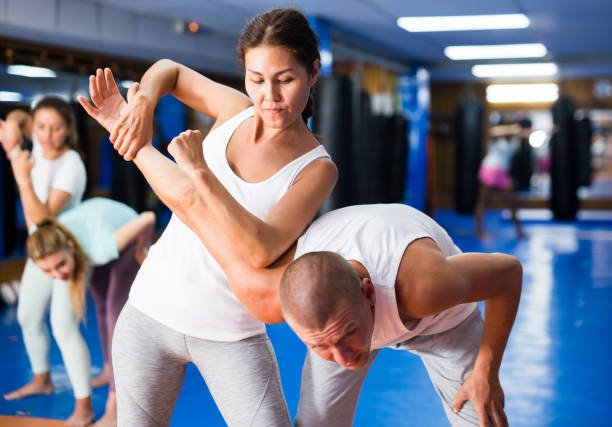 istock Asian woman practicing self-defence moves with her trainer 1488257752