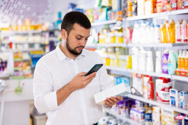 istock Male customer scans barcode on a medicine box using her smartphone 1488257879