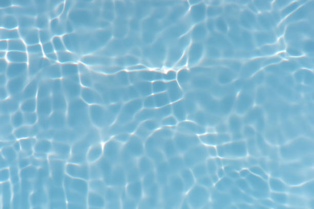 istock Blue water with ripples on the surface. Defocus blurred transparent blue colored clear calm water surface texture with splashes and bubbles. Water waves with shining pattern texture background. 1488259403