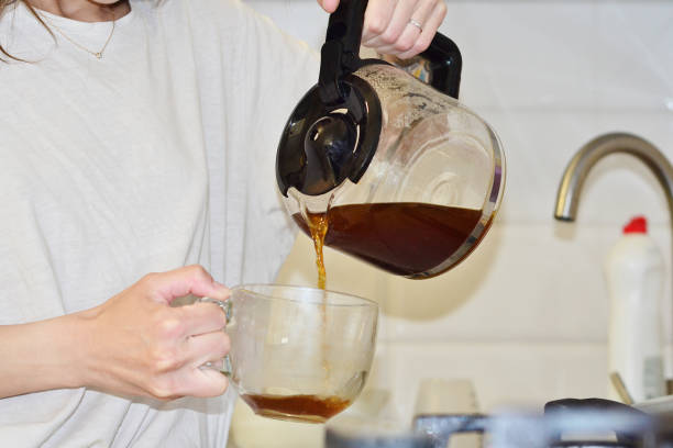 istock The girl pours coffee from a teapot into a cup 1488262943