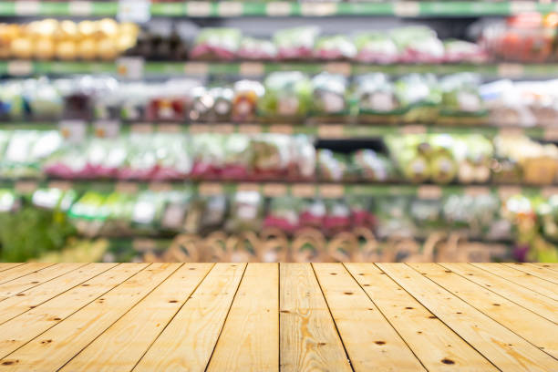 istock Wood table top with vegetables on grocery store shelves blurred background 1488264412