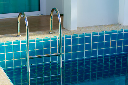blue swimming pool at hotel with stair.