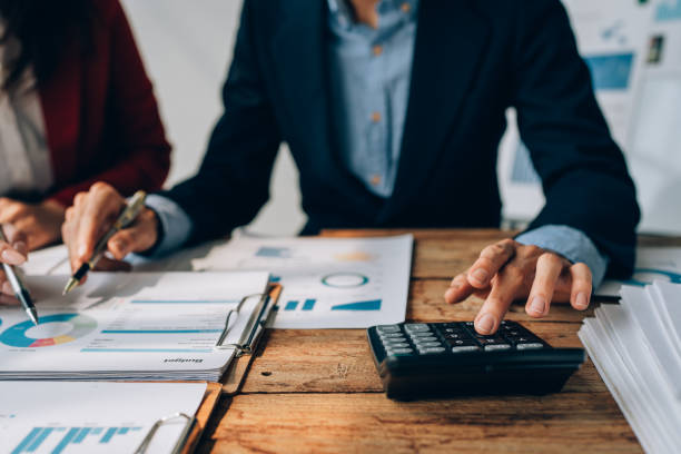 istock Two business people meeting to talking or discuss marketing work in workplace using paperwork, calculator, computer to work 1488266384