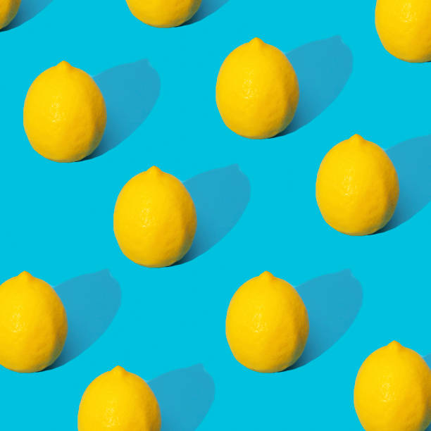 istock Juicy yellow lemons on a blue background with hard shadows. Summer pattern with ripe lemons. 1488272007