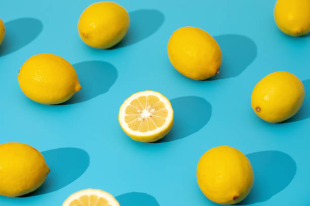 istock Juicy yellow lemons on a blue background with hard shadows. Summer pattern with ripe lemons. 1488272008