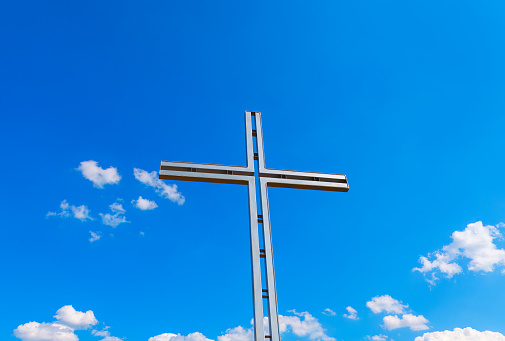 Christian cross against sky and clouds . Spiritual religion heaven
