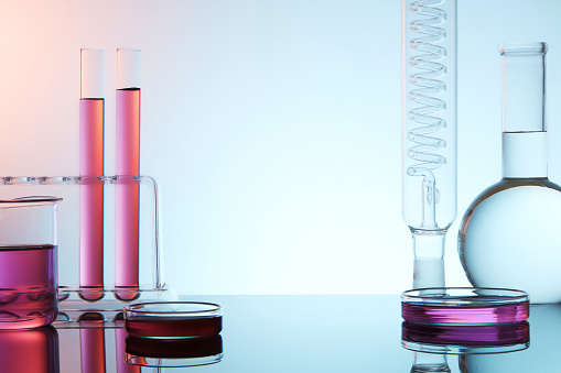 Front view of lab glassware filled colorful liquid on light background. Empty space for display product and text. Science laboratory research and development concept