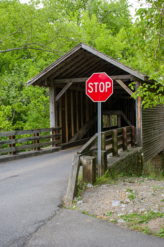 A stop sign at a covered bridge road.