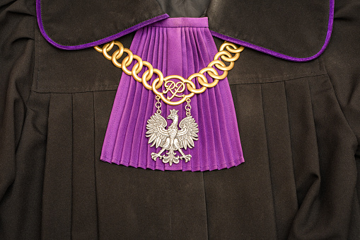 A judge's outfit in Poland in macro close-up.  Black gown with purple jabot and chain