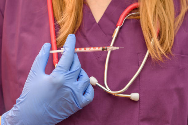 female doctor that has a surgical syringe in her hand with a stethoscope around her neck