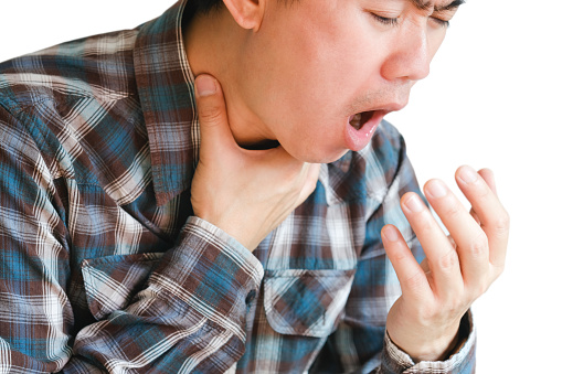 Close-up of a man with sore throat and tonsillitis in the throat. He put his hand on his neck. health and medical concepts