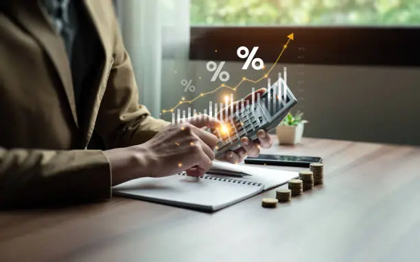Photo of Interest rate and dividend concept, Businessman is calculating income and return on investment in percentage. income, return, retirement, compensation fund, investment, dividend tax, stock market