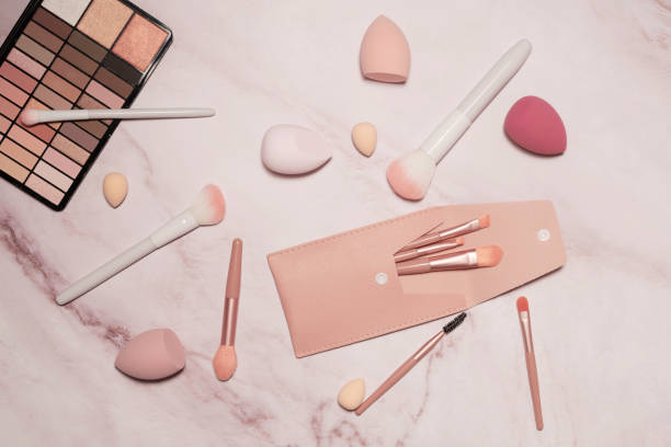 istock A nude eyeshadow palette and makeup artist's tools on a marble vanity. Brushes for powder, blush, eyebrows, shadows and sponges for concealer and foundation. 1488283277