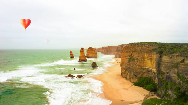 os doze apóstolos, austrália. balões de ar em forma de coração em melbourne. grandes destinos de viagem rodoviária oceânica - australia melbourne landscape twelve apostles - fotografias e filmes do acervo