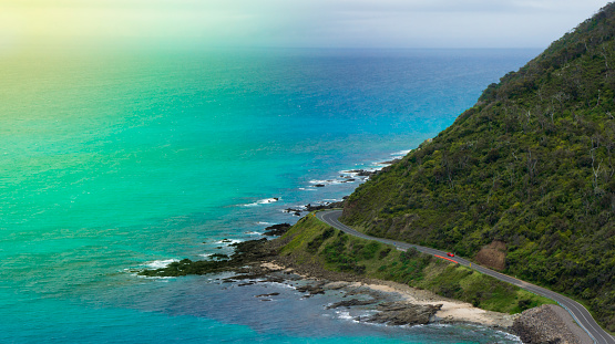 Amazing Nature by the Great Ocean Road in Australia. Beautiful sunny day. Red car on the ocean road