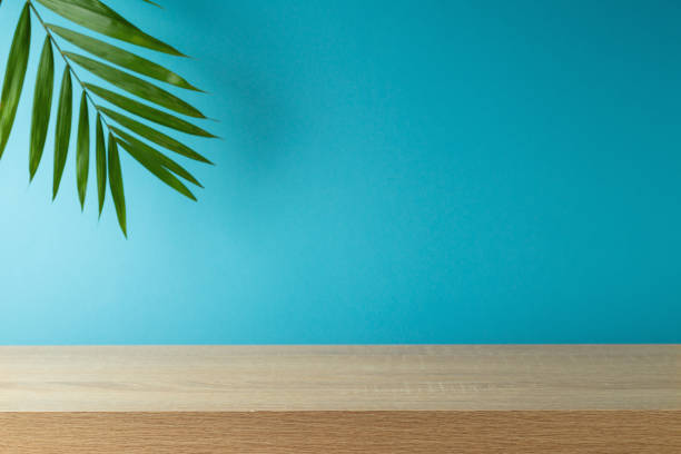 istock Empty wooden table with palm tree leaf over blue background . Summer mock up for design and product display 1488294809