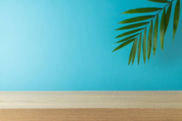 istock Empty wooden table with palm tree leaf over blue background . Summer mock up for design and product display 1488294812