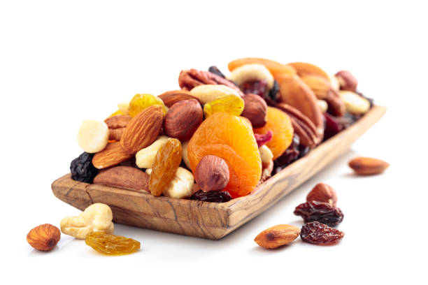 Mix of nuts and dried fruits isolated on a white background. Mix of nuts and dried fruits isolated on a white background. Presented apricots, raisins, walnuts, hazelnuts, cashews, pecans, and almonds. dried fruit on white stock pictures, royalty-free photos & images