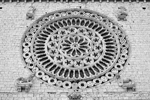 Medieval italian rose window against a stone wall - Italy - Assisi Church of Saint Francesco