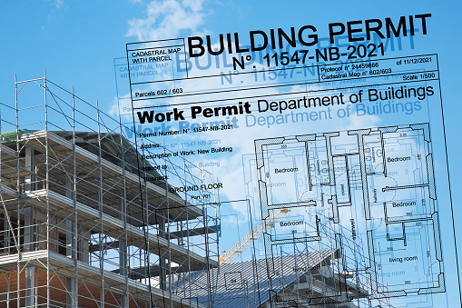 Buildings Permit project concept with residential building construction and metal scaffolding on a construction site