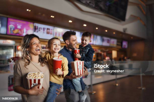 Young Happy Family With Popcorn And Drinks In Movie Theatre Stock Photo - Download Image Now