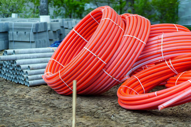 istock Red plastic pipes rolled into rings and other building materials 1488300736
