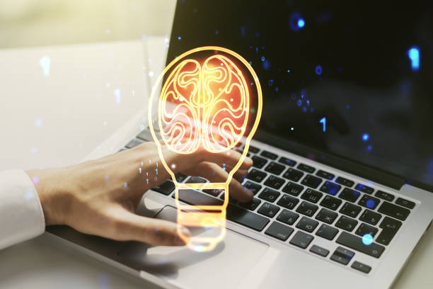 istock Creative light bulb with human brain hologram and with hands typing on computer keyboard on background, artificial Intelligence and neural networks concept. Multiexposure 1488300763