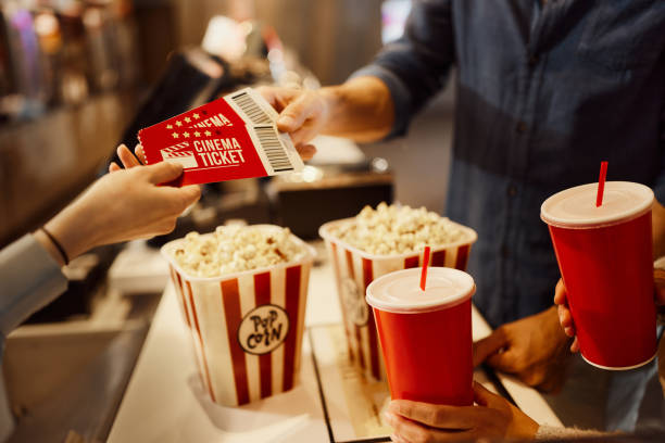 Buying movie tickets! Close up of unrecognizable cashier giving movie tickets to her customer in cinema. box office stock pictures, royalty-free photos & images