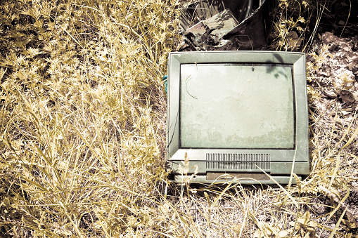 Old television CRT abandoned in a illegal dump - toned image