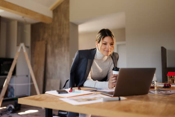 istock Female interior designer working on a computer at renovating house 1488301877