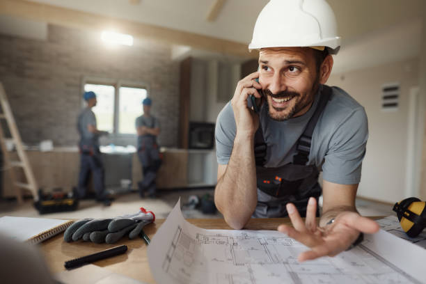 istock Happy manual worker talking on cell phone during home renovation process. 1488301918