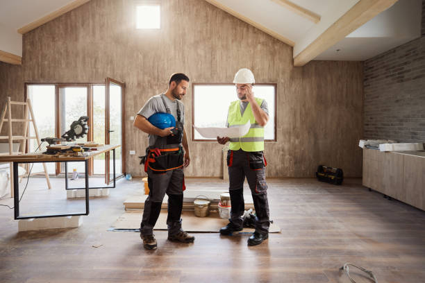 istock Manual workers examining housing plan at renovating house. 1488301959