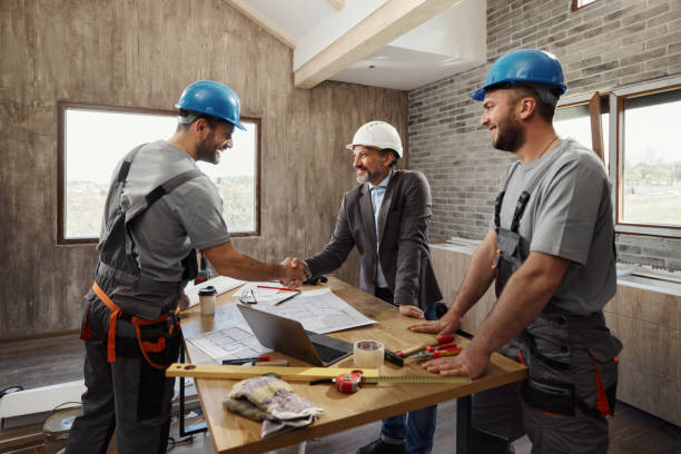 istock Happy architect came to an agreement with workers at renovating home. 1488302028