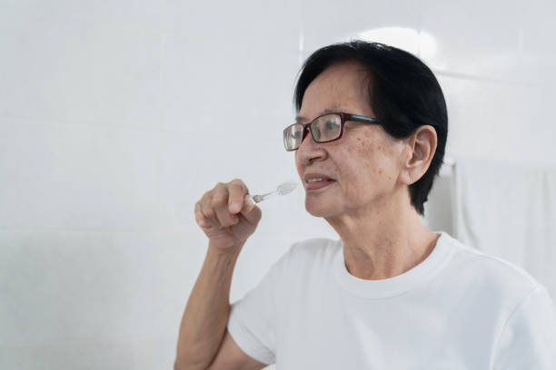 istock Mature Asian Woman Doing Morning Routine by Brushing Teeth After Waking Up. 1488303858