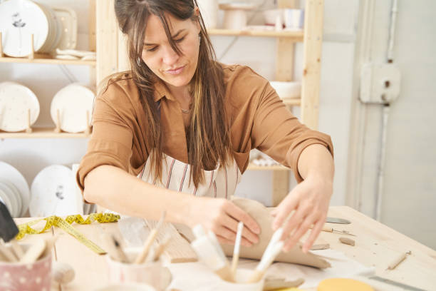 istock Woman painting and decorating a pottery in a ceramic workshop. 1488303923