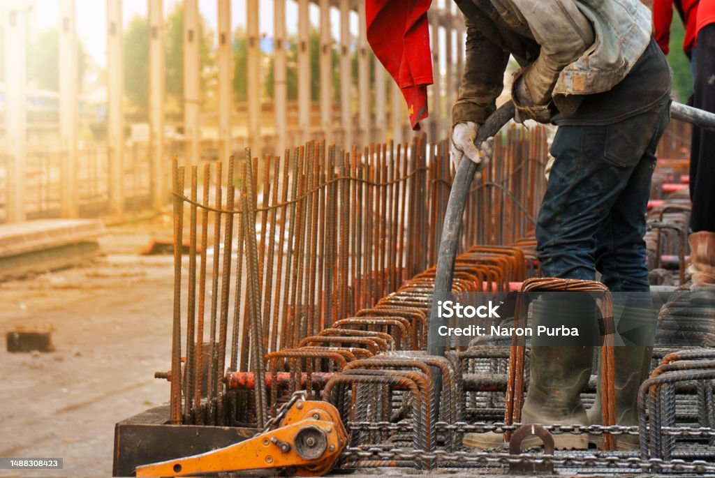 Construction workers are leveling the cement mortar using a special vibrator for concrete Mortar concrete for Precast and  prestress industry Concrete Stock Photo
