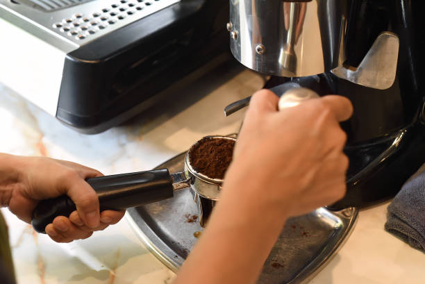 istock Hands pressing coffee beans for a coffee machine close up 1488311259