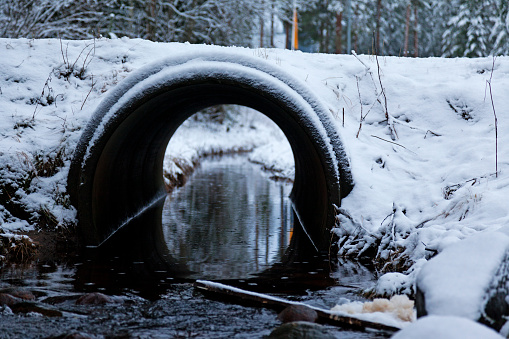 small road tunnel in winter where a stream can flow through