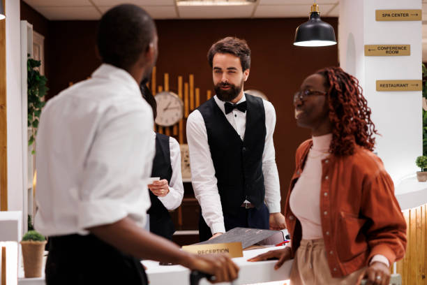 istock Hotel staff welcoming guests at counter 1488312406