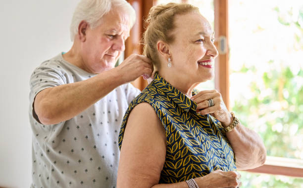 Senior man helping wife put on a necklace