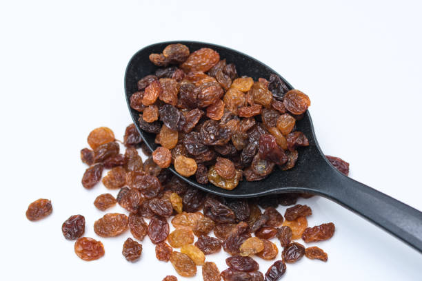 istock Sultana raisins isolated on a kitchen black spoon 1488313859