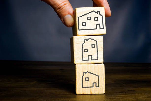 istock The hand puts a cube with a drawn house. Property investment concept. 1488314049