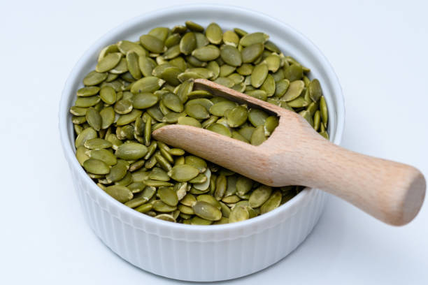 istock Green pumpkin seeds without shell in a dish on a white background 1488314396