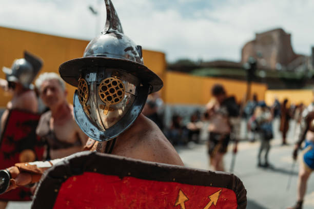 Rome, Italy, April 23, 2023: Parade for the birth of Rome on April 23, 2023 in Rome, Italy. People dressed in costume as gladiators, centurions, senators, handmaids and ancient romans citizens walk in parade under the Coliseum of Rome, to celebrate the birth of the Eternal City.