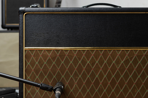 Vintage guitar amp with microphone in front of a speaker