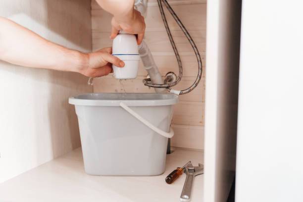 istock The plumber disassembles the siphon under the sink to clear the blockage. 1488319486