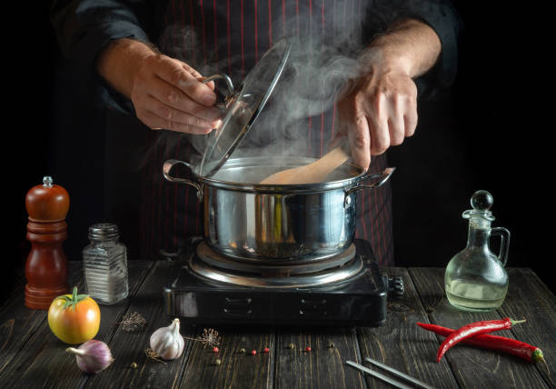 istock The chef cooks a delicious soup with vegetables in a hot pot. Work environment on the kitchen table. Menu for the hotel 1488321382